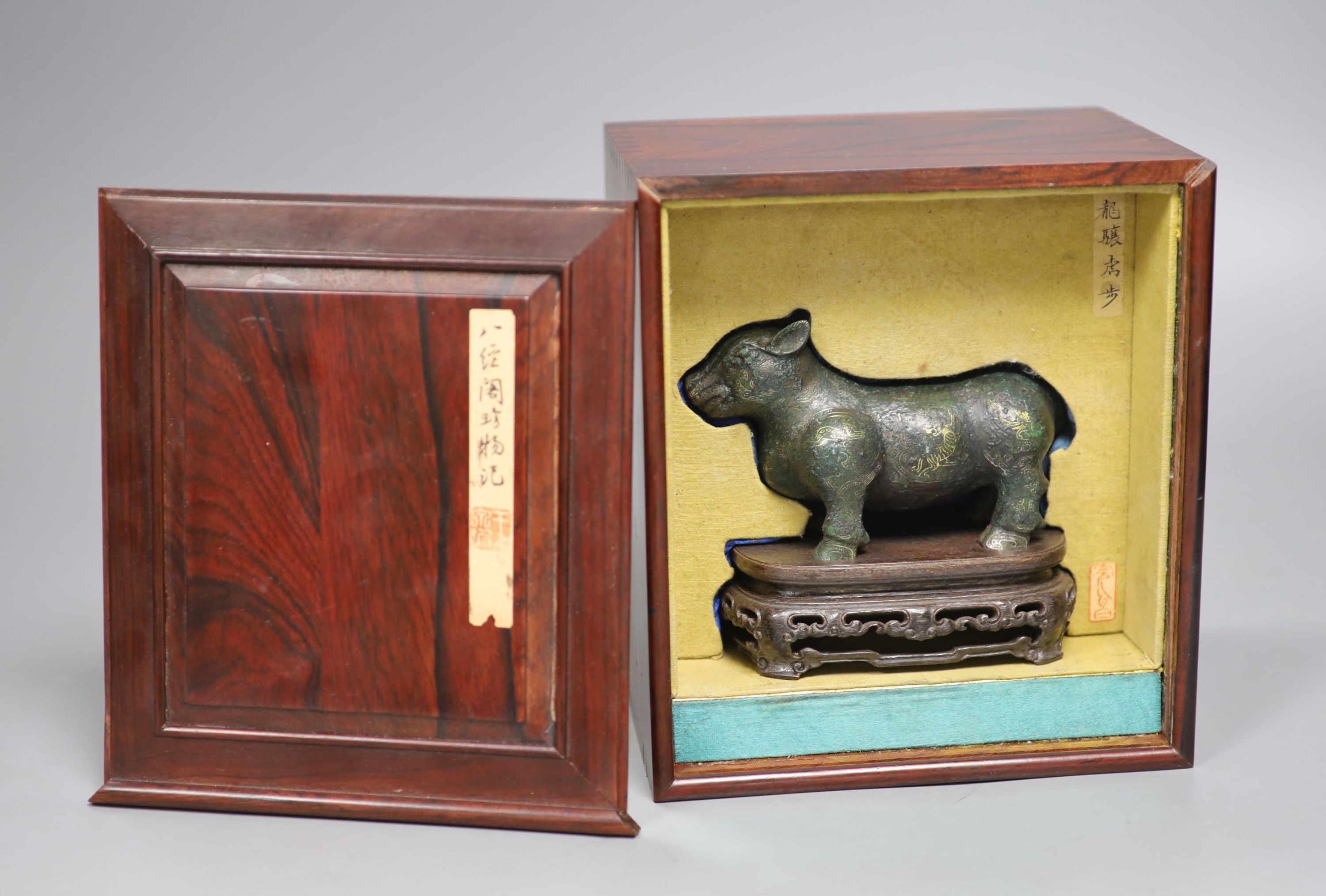 A Chinese gold and silver inlaid bronze figure of a tapir, Han dynasty or later, L. 12cm, excluding hardwood stand and fitted box